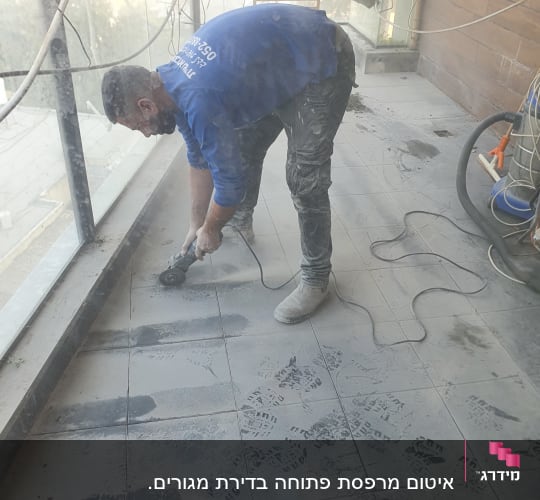 אדם חותך אריחים עם כלי חשמלי על רצפה